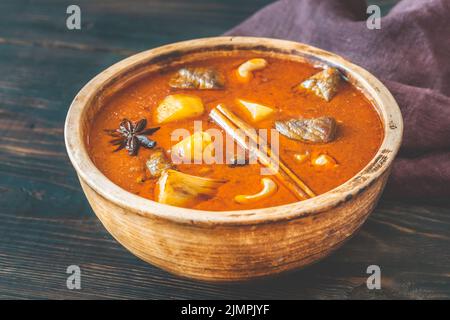 Schüssel mit Massaman-Schälchen auf dem Holzhintergrund Stockfoto