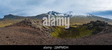 Spektakuläre vulkanische Aussicht vom Saxholl Krater, Snaefellsnes Halbinsel, West Island. Der schneebedeckte Vulkan Snaefellsjokull ist weit oben. Stockfoto