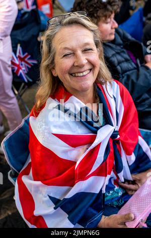 Eine Britin mittleren Alters, die über Nacht entlang der Mall gezeltet hat, wartet auf die Queen's Birthday Parade, The Mall, London, Großbritannien. Stockfoto