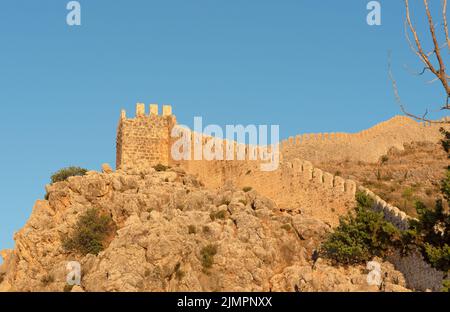 Die Festungsmauer vor dem Hintergrund eines strahlend blauen Himmels an einem sonnigen Tag in Alanya. Stockfoto