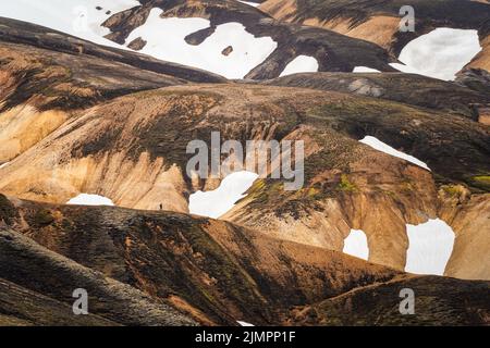 Landschaftlich reizvoller vulkanischer Berg mit schneebedeckten Bergen und Wanderwegen auf dem Bergrücken im Fjallabak-Naturschutzgebiet im isländischen Hochland bei Landmannala Stockfoto