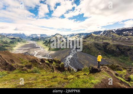 Landschaft des Aussichtspunktes von Valahnúkur mit Wanderweibchen, die auf dem Gipfel stehen und durch den krossa-Fluss im isländischen Hochland bei Thórsmörk, Island, fließt Stockfoto