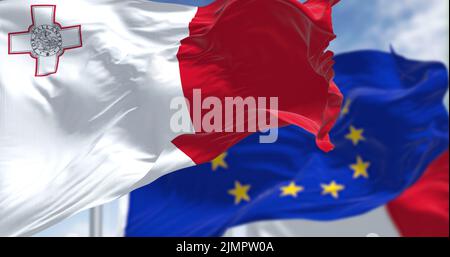 Detail der im Wind winkenden Nationalflagge von Malta mit verschwommener flagge der europäischen Union im Hintergrund Stockfoto