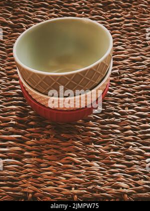 Kleine leere Keramik-Messbecher auf rustikalem Weidenhintergrund, Lebensmittelzubereitung Flatlay und Kochdesign Stockfoto