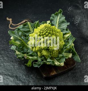Romanesco Brokkoli Kopf auf einer dunklen Steinoberfläche, Kohl, Nahaufnahme, fibonacci-Sequenz, für diejenigen, die Mathematik lieben Stockfoto
