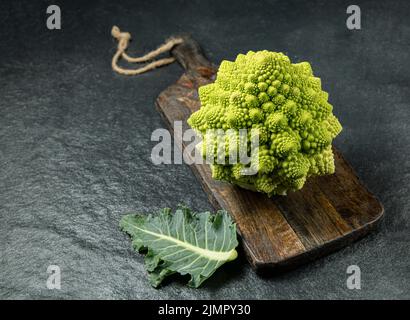 Romanesco Brokkoli Kopf auf einer dunklen Steinoberfläche, Kohl, Nahaufnahme, fibonacci-Sequenz, für diejenigen, die Mathematik lieben Stockfoto