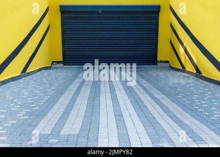 Eingang zur Tiefgarage von der Straße in einem Wohnhaus. Geschlossenes Tor. Stockfoto