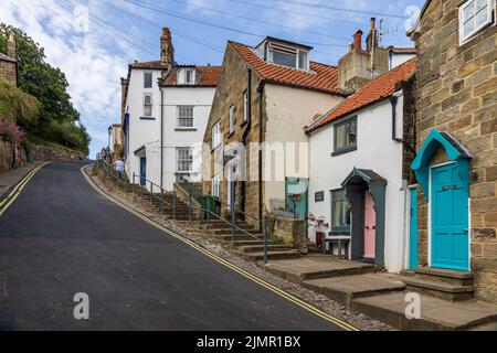 Der steile Hügel von der Strandpromenade und dem Strand im alten Fischer- und Schmuggeldorf Robin Hood's Bay in North Yorkshire, England Stockfoto