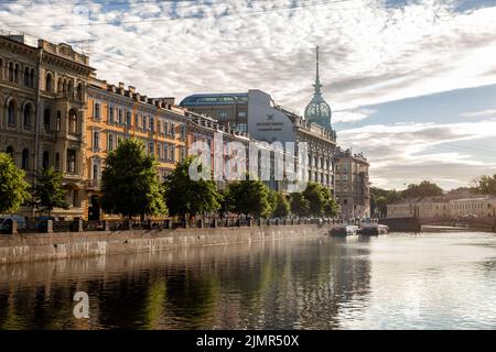St. Petersburg, Russland - 17. Juli 2022: Ufer des Flusses Moyka. Alte Herrenhäuser und Kaufhaus „an der Roten Brücke“ (Au Pont Rouge) Stockfoto