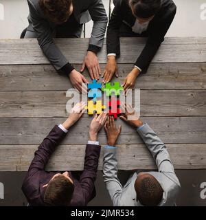 Vielfältiges Team Menschen Montage Puzzle, multiethnische Gruppe von schwarzen und weißen Kollegen engagieren in erfolgreiche Teamarbeit Vermittlung von solutio Stockfoto