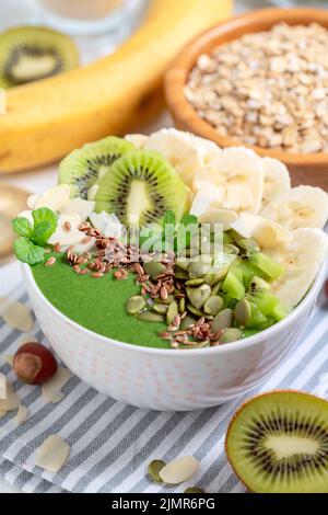 Smoothie-Schüssel zum Frühstück mit Spinat, Banane und Kiwi-Früchten. Stockfoto