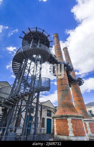 Berühmte Schornsteine der Waffenfabrik Le Manu aus dem 19.. Jahrhundert mit einer 18 Meter hohen Wendeltreppe aus Metall und Gehweg, Chatellerault, Vienne (86), Frankreich. Stockfoto