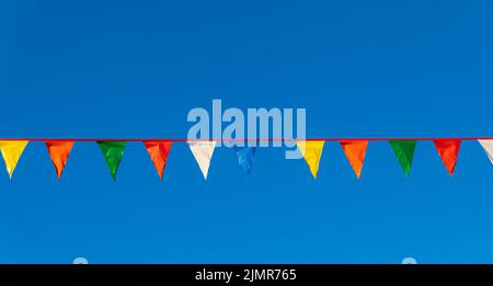 Party Fahnen bunt feiern abstrakt auf blauem Himmel Hintergrund. Bunten mit bunten dreieckigen Fahnen vor blauem Himmel. Niemand. Stockfoto