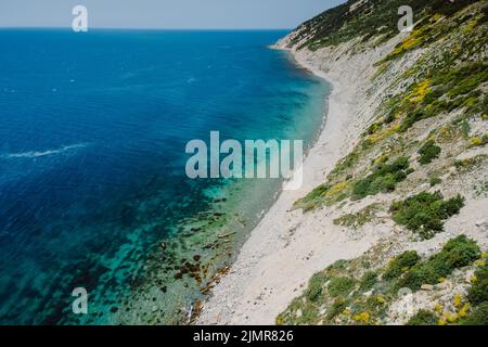 Luftaufnahme der Küste mit transparentem Meer und Klippen. Sommertag auf dem ruhigen blauen Meer Stockfoto