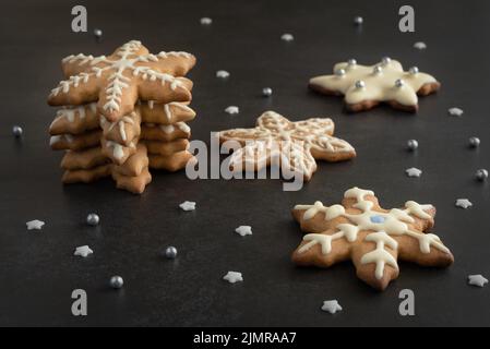 Weihnachts-Lebkuchenkekse mit Zuckereiben in Form von Schneeflocken verziert. Stockfoto
