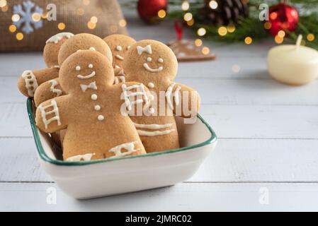 Lebkuchenmänner in einer Schüssel Nahaufnahme auf einem weihnachtlichen Hintergrund. Stockfoto