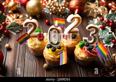 Neujahr Cupcakes mit Zahlenkerzen mit Regenbogenfahnen Stockfoto