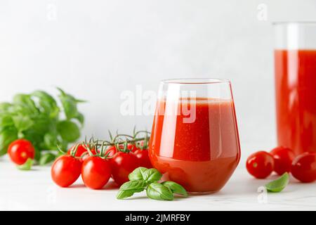 Tomatensaft im Glas und frische Tomaten Stockfoto