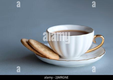 Eine starke Tasse traditionellen englischen Tee, mit Milch und zwei reichen Tee-Keksen. Serviert in einer klassischen Bone china Tasse und Untertasse. Ein schönes erfrischendes Gebräu Stockfoto