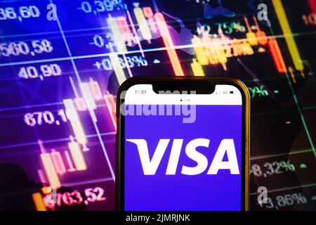 KONSKIE, POLEN - 07. August 2022: Smartphone mit dem Logo von Visa Inc auf dem Hintergrund des Börsendiagramms Stockfoto