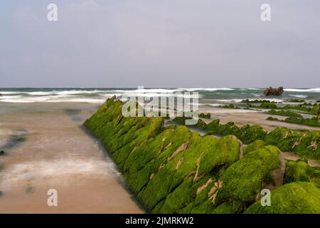 Eine lange Sicht auf die Felsformationen von Flysch bei Ebbe am Strand von Barrika in der Nähe von Bilbao Stockfoto