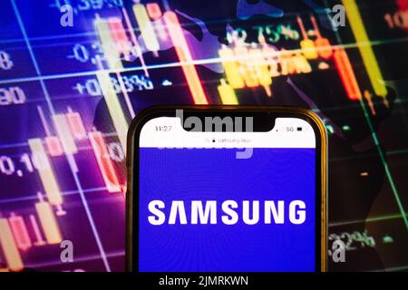 KONSKIE, POLEN - 07. August 2022: Smartphone mit Logo der Samsung Group auf dem Hintergrund des Börsendiagramms Stockfoto