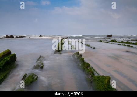 Langzeitansicht der Felsformationen von Flysch bei Ebbe am Strand von Barrika in der Nähe von Bilbao Stockfoto