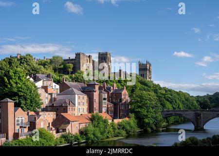 DURHAM, ENGLAND - 3.. JULI 2022: Blick auf die Häuser entlang des Flusses Wear, das Schloss und die Kathedrale in Durham an einem sonnigen Sommernachmittag Stockfoto