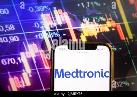 KONSKIE, POLEN – 07. August 2022: Smartphone mit Logo der Medtronic plc auf dem Hintergrund des Börsendiagramms Stockfoto