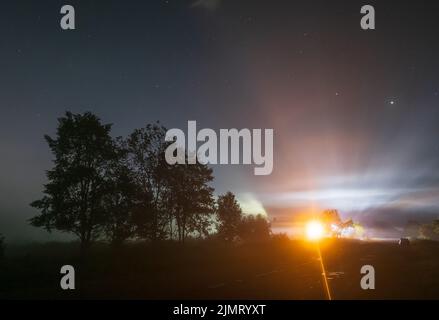 Komet Neowise C2020 F3, wie er im Sommerhimmel über einer Wiese in der Nähe der Landstraße, Region Lviv, Ukraine fliegt. Stockfoto