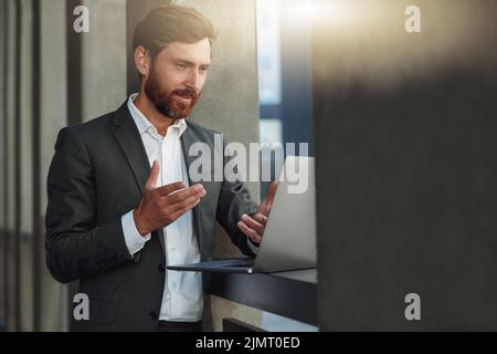 Lächelnder Geschäftsmann macht Videocall für Kunden, die in der Nähe des Bürogebäudes stehen Stockfoto
