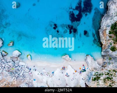 Golfo di Orosei Sardina, Blick von oben, atemberaubende Luftaufnahme des Strandes voller Sonnenschirme und Sonnenbaden und Schwimmen Stockfoto