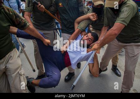 Srinagar, Indien. 06. August 2022. Polizisten verhaften muslimische schiitische Trauernde aus Kaschmir, die versuchen, an einer Muharram-Prozession in Srinagar teilzunehmen. Dutzende schiitisch-muslimische Trauernde wurden von der indischen Polizei festgenommen, als sie versuchten, während des Muharram, dem ersten Monat des islamischen Mondkalenders, an der Prozession teilzunehmen. Indien hat alle Prozessionen und ähnliche öffentliche Zusammenkünfte in Kaschmir verboten, nachdem 1989 eine Rebellion gegen die indische Herrschaft ausbrach. (Foto von Faisal Bashir/SOPA Images/Sipa USA) Quelle: SIPA USA/Alamy Live News Stockfoto