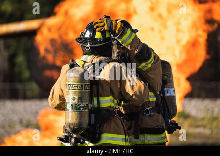 Edward Williams, links, und U.S. Air Force Senior Airman Jacob Warren, 6. Civil Engineer Squadron Firefighters, passen ihre Schutzausrüstung an, bevor er sich an einer Flugzeugrettung und Feuerwehrentwicklung auf der MacDill Air Force Base, Florida, 5. August 2022, einlässt. Jedes dem 6. Air Betanking Wing zugewiesene Stratotanker KC-135 kann mit über 30.000 Gallonen Strahlkraftstoff beladen werden, was im Falle eines Flugzeugverlustrisikos ein Brandrisiko darstellt. ARFF-Schulungen helfen den Feuerwehrleuten der Luftwaffe, gefährdete Flugzeuge in Notsituationen zu verwalten. (USA Luftwaffe Foto von Airman 1. Klasse Joshua H Stockfoto