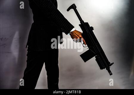 Geschäftsmann mit einem Maschinengewehr zu kämpfen Stockfoto