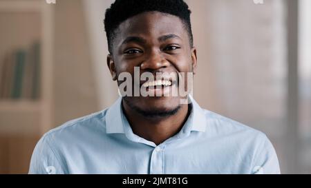 Afrikanisch gut aussehend freundlich Mann amerikanisch jung Kerl blogger Lehrer Trainer sagen hallo Blick auf Kamera Welle Hand Gruß Rekord Lifestyle Blog pädagogisch Stockfoto
