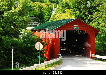 Eine Kirche ragt durch die Bäume in der Nähe der bezaubernden Arlington Covered Bridge in Neuengland Stockfoto