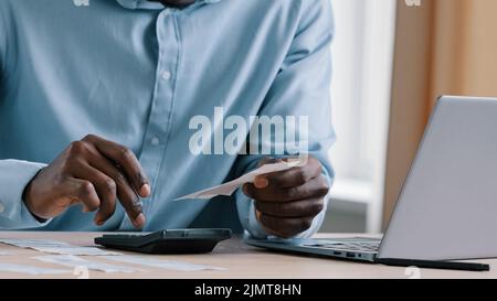 Close up unbekannter afrikanischer Mann Bankkaufmann Buchhalter halten Zahlungseinkommen Ergebnisse Stromrechnungen machen Berechnung der unbezahlten Bankschuld Machen Sie Audit-Check Stockfoto