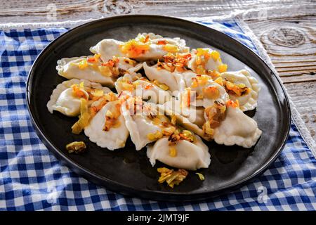 Komposition mit einem Teller klassischer Pierogien mit Zwiebeln Stockfoto