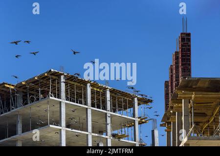 Auf dem Weg wird ein mehrstöckiges Mehrfamilienhaus errichtet, an dem noch gearbeitet wird Stockfoto