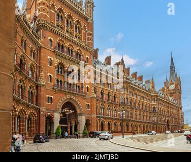 London, Großbritannien - 3. Juli 2022: Historisches St. Pancras Renaissance Hotel aus rotem Backstein unter blauem Himmel mit Autos vorne. Stockfoto