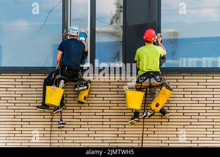 Zwei Männer putzten Fenster in einem Bürogebäude Stockfoto