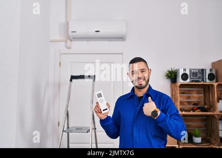 Hispanischer Reparaturman, der mit der Klimaanlage arbeitete, zeigte den Finger auf einen selbst, der glücklich und stolz lächelte Stockfoto