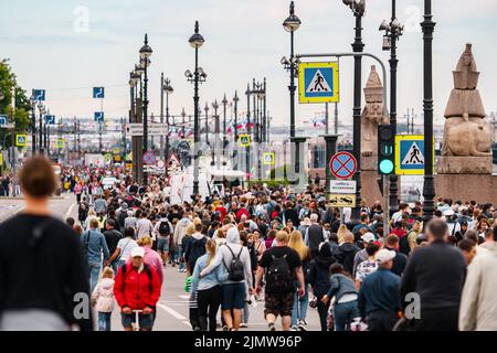 Russland, St. Petersburg, 31. Juli 2022: Viele Menschen während der Feier des Tages der Marine auf der Universität Böschung, Laternenpfosten Stockfoto