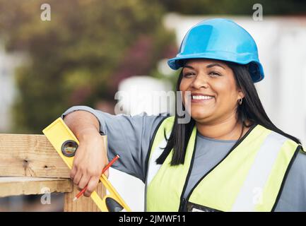 Ich bin hier fast fertig. Beschnittenes Porträt einer attraktiven jungen Bauarbeiterin, die auf der Baustelle arbeitet. Stockfoto