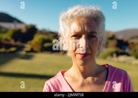 Nahaufnahme des Porträts einer ernsthaften kaukasischen älteren Frau vor dem klaren blauen Himmel im Hof des Pflegeheims Stockfoto