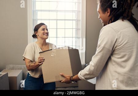 Ill tun alle schweren Heben für Sie. Ein glückliches junges Paar in ihr neues Zuhause ziehen. Stockfoto