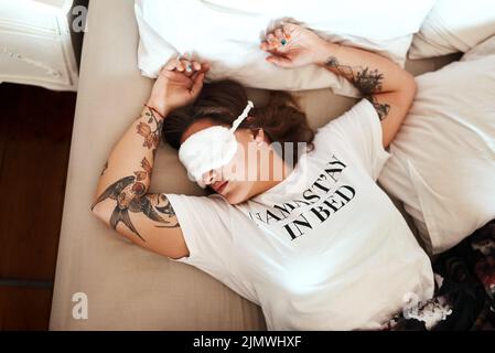 Nichts und niemand wird meinen Schlaf unterbrechen. Eine junge Frau, die eine Schlafmaske trägt, schläft zu Hause in ihrem Bett. Stockfoto