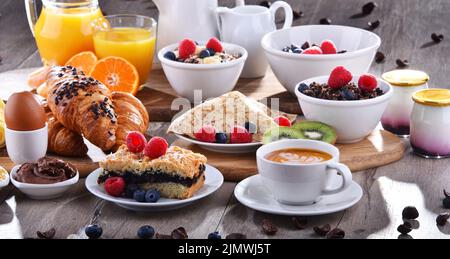 Frühstück serviert mit Kaffee, Saft, Croissants und Obst Stockfoto