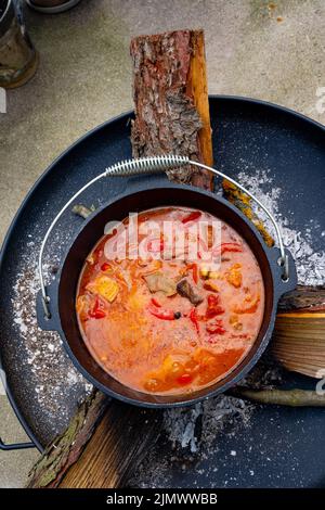 Über einem offenen Feuer wird Wassergulasch zubereitet! Stockfoto